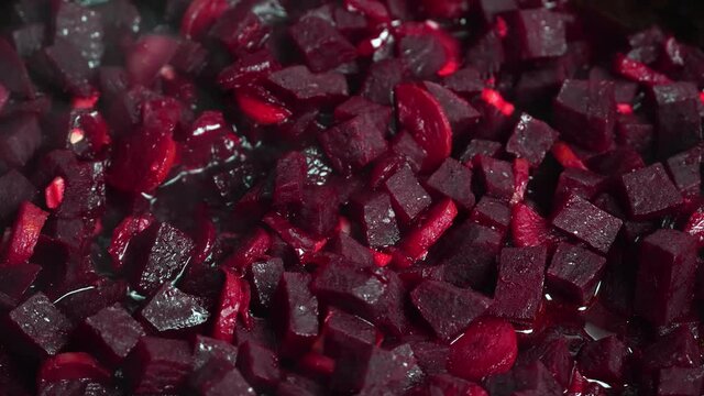 Cooking beetroot in a frying pan. Roasting for cooking borscht. Ukrainian cuisine. Mixing of crushed beets on a gas stove. Preparation of salad or soup.