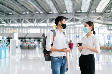 New normal,travel bubble and social distancing concept.Traveler man and woman wearing face mask and waiting to board at terminal airport for protection coronavirus(covid-19) during virus pandemic