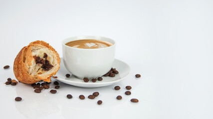 Cup of Cafe Latte Coffee on plate with Leaf Pattern, croissant with hazelnut and chocolate filler and seeds on white background. Enjoyment and freshness. Graphic for kitchen or cafe store. 