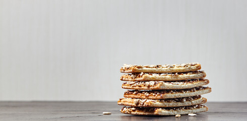 Crisp bread with seeds. Crunchy crispbread on a wooden background. Healthy snack: cereal crunchy multigrain cereal flax seed, sunflower seeds protein bread bar
