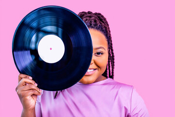 hipster lady with cool dreadlocks pigtails showing old fashion school vinyl in pink studio background