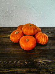 Fresh assorted colorful golden pumpkins in autumn, standing on an old wooden table