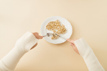 A woman cuts a gold chain in a plate. Artistic Concept