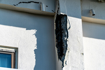 劣化して鉄筋がむき出しになった建物の外壁,
