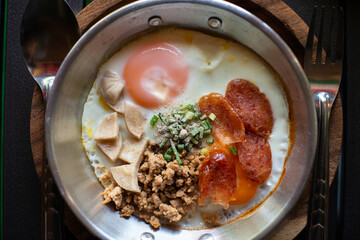 Breakfast with eggs, minced pork, sausage slices arranged in a pan and ready to serve.