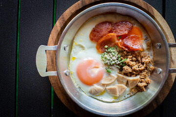 Breakfast with eggs, minced pork, sausage slices arranged in a pan and ready to serve.