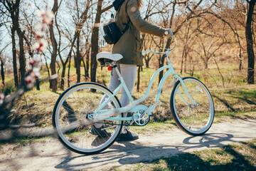 Fototapeta na wymiar Young woman with her bike walking in park