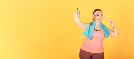 Smiling woman with oversized body makes selfie after workout
