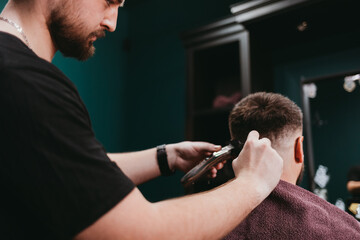 Young guy barber making haircut to client man