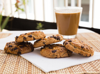 cookies with chocolate and hazelnuts and coffee with milk lie on the table