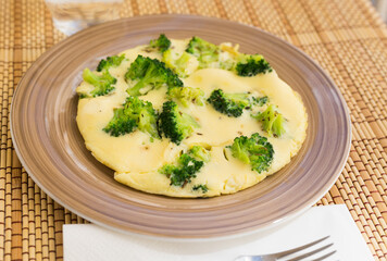 wholesome breakfast. omelet with broccoli on brown plate