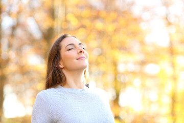 Female breathing fresh air in autumn in a forest