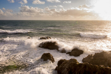Waves crash along Bodega Bay in northern California at sunset.