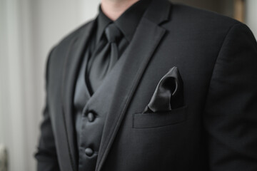 Cropped view of the groom in total black suit Black tie black shirt Black waistcoat Wedding details...