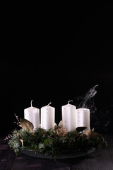 First Advent - Advent wreath from fir and evergreen branches with blown out candle on dark wooden...