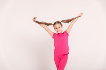 happy child on a white background. a girl in a pink T-shirt and pants.