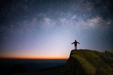 Silhouette of young traveler and backpacker watched the star, milky way and beautiful view night...