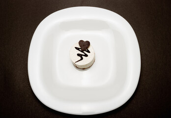 cake with heart on white plate and dark background 