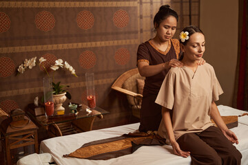 Beauty salon worker working trigger points on patient shoulders