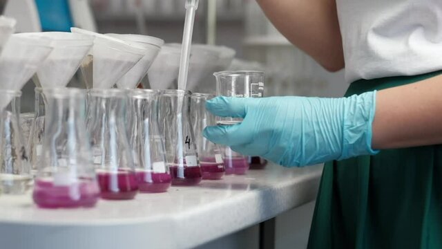 chemical laboratory, the laboratory assistant takes the reagent into the syringe and pours it into a test tube