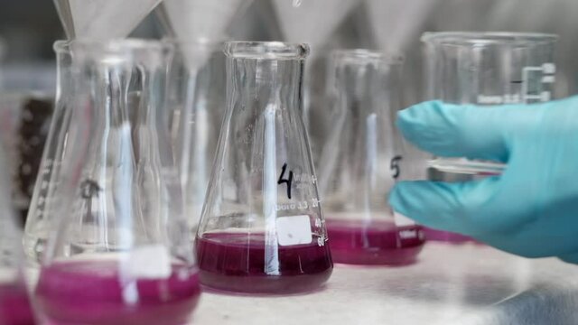 chemical laboratory, the laboratory assistant takes the reagent into the syringe and pours it into a test tube