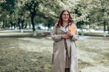 Portrait of young beautiful woman student walking in the park