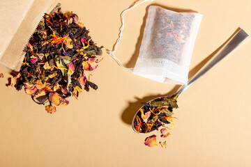 Black tea, herbal and fruit brewed in a transparent cup. Tea for brewing in tea bags. The concept of a natural healthy drink. Tea bags on beige background