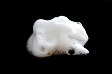 White foam bubble soap, cleanser or shampoo isolated on black background
