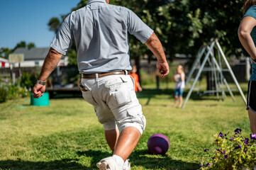 Playing kickball with grandpa in the backyard