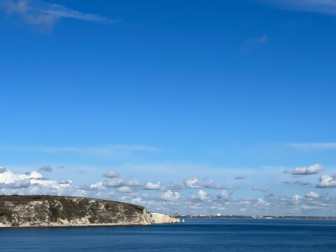 view of old harry rocks from Swanage, sea and chalk cliffs with Bournemouth in the background