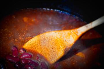 Fototapeta premium Stirring beans into a cooking pot of chili