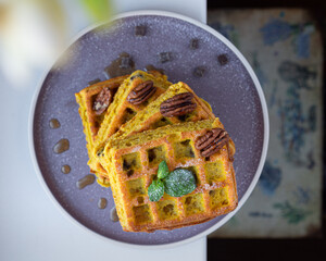 pumpkin waffles with pecan nuts and maple syrup