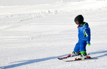 Fototapeta na wymiar Young child learning to ski in the mountain