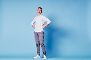 Full length studio portrait of handsome young man on blue background.