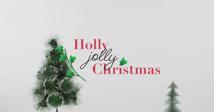 Animation of holly christmas text over fir tree