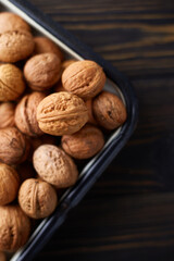 Natural whole walnuts on dark wooden table. Top view, flat lay with copy space