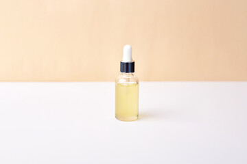 Essential oil in dropper bottle on white and yellow background. Natural medicine concept. Aromatherapy