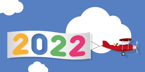 Carte de vœux humoristique, montrant un avion rouge à hélice tirant une banderole blanche, annonçant l’arrivée de l’année 2022.