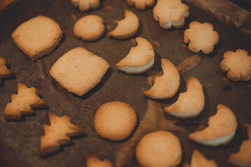 Homemade Christmas cookies on a baking sheet on a wooden table.