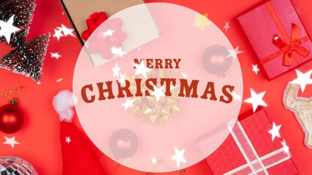 Animation of merry christmas text over christmas decoration and presents on table