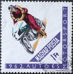 Hungary circa 1962: A post stamp printed in Hungary showing a man in motorcycle clothing on a...