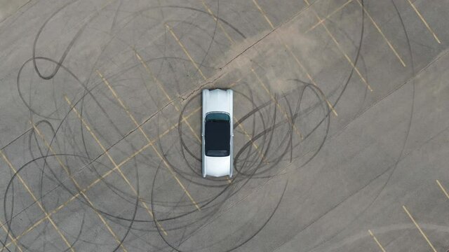 Old Car in a parking lot with tire marks drone footage rising