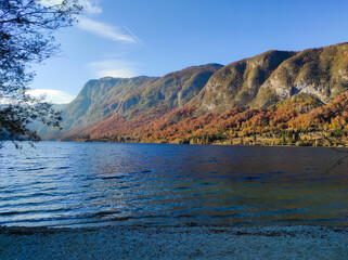 Bohinj lake in Triglav national park, Slovenia. Autumn landscape in the dusk, scenic view of the water, mountains and colorful trees 