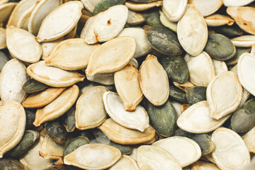 Dry Roasted Pumpkin seeds background. Tasty and healthy food. Close up photo.