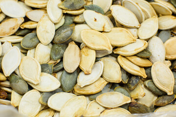 Dry Roasted Pumpkin seeds background. Tasty and healthy food. Close up photo.