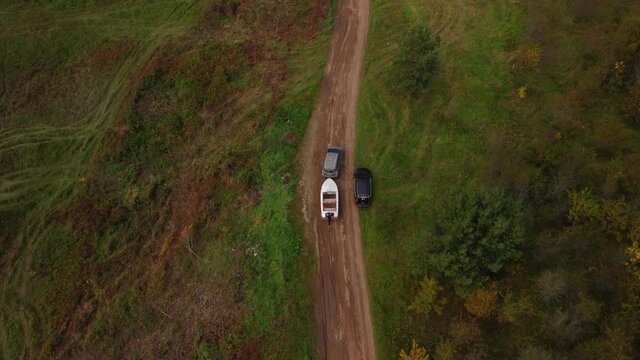 A Drone Tracking Shot Of A Car Towing A Boat On A Country Road