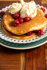 Top view of pancakes with mascarpone cheese and cherries, in portrait, with copy space