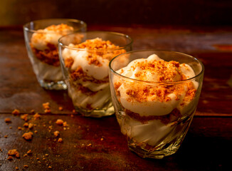 three glasses with yogurt and crumbled - low light key