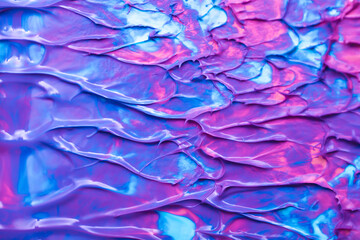 Beautiful abstract background with spots of blue, pink, green, yellow and purple paint. Oil paint, flowing down the canvas, shimmers with galagrophic paints with neon illumination.