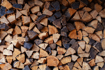 chopped wood firewood of different sizes, stacked in rows